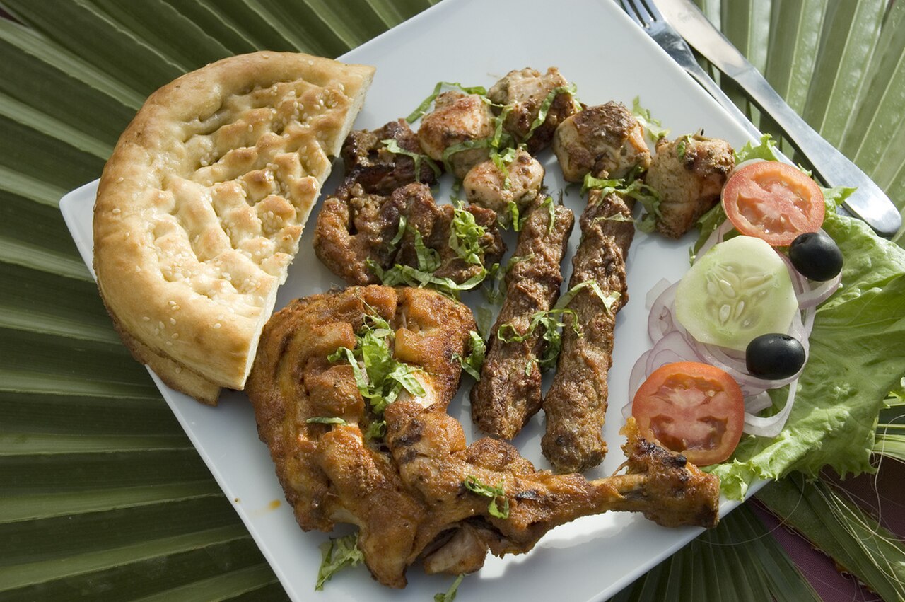 Chicken tikka pieces with charred edges on a plate